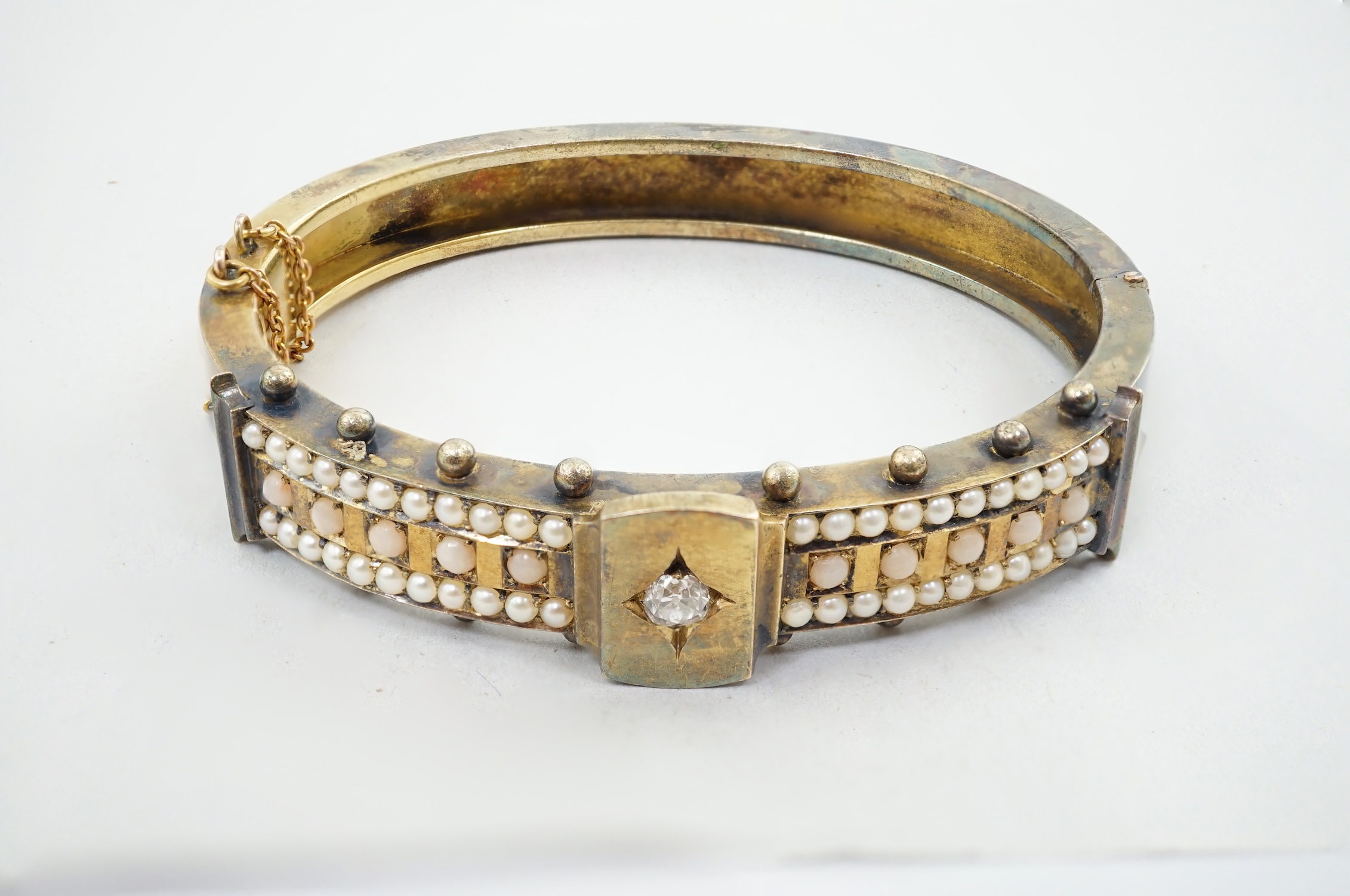 A Victorian, gold, single stone diamond and seed pearl and coral bead cluster set hinged bangle